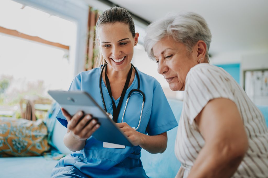 A staff member showing a tablet to a resident