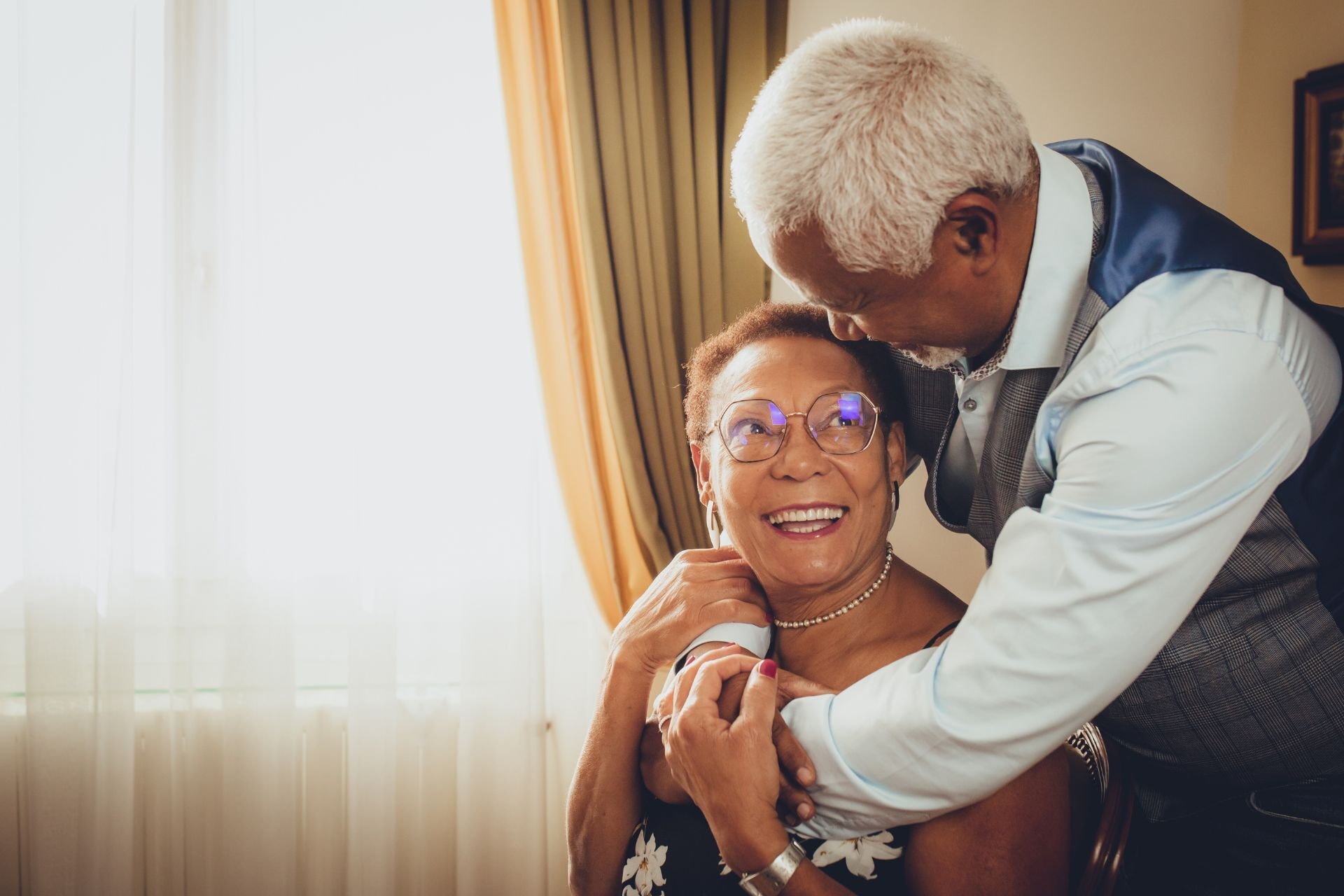 A woman smiling while being assisted by a man indoors