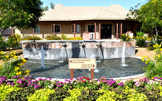 Exterior view of the facility with landscaping and fountain.