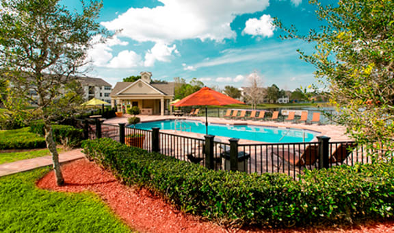 Outdoor pool area with lounge chairs and umbrellas.