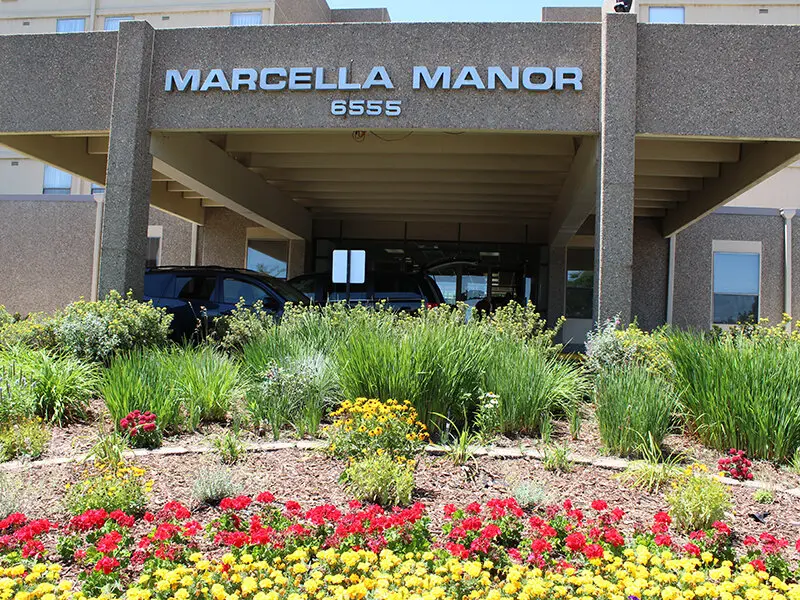 Exterior view of Marcella Manor with flowers in the foreground