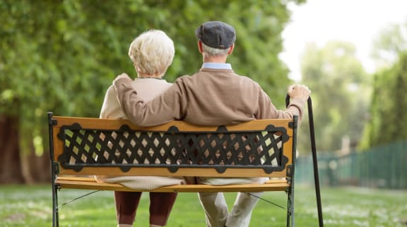 Elderly couple sitting on a bench in a garden
