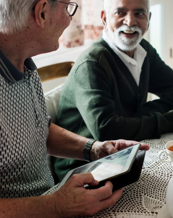 Two residents laughing and engaging over a tablet