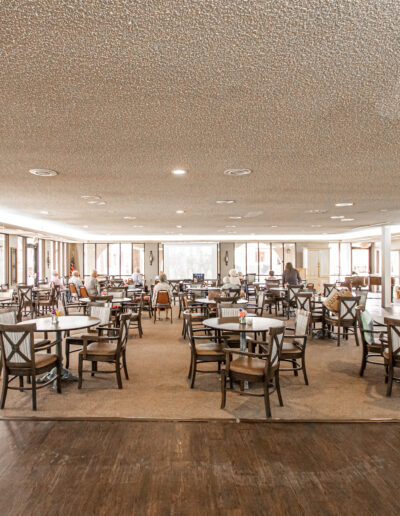 Bright dining room with tables and chairs set up