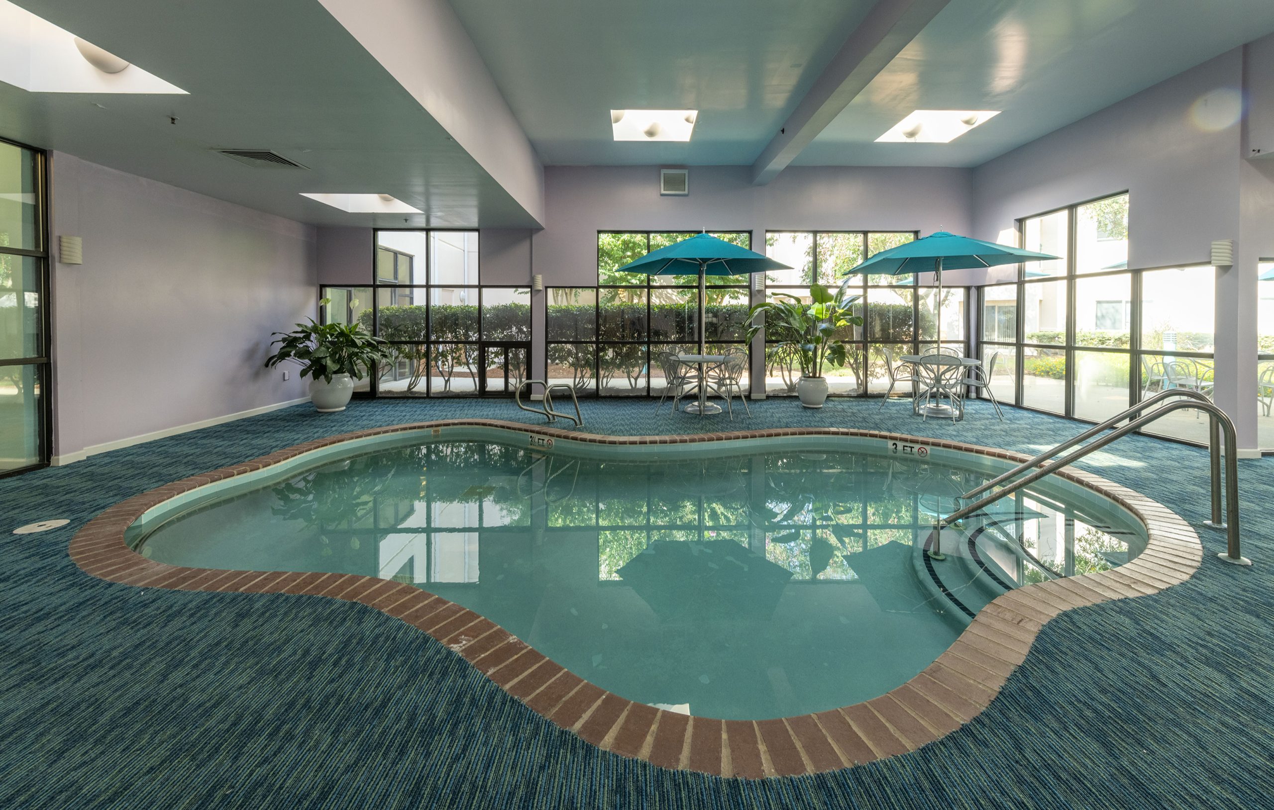Indoor pool area with seating and plants