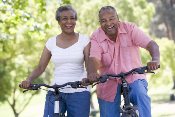 Two seniors enjoying a bike ride together outdoors