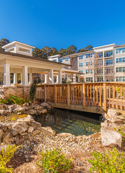 Outdoor view of a bridge over a pond with landscaping