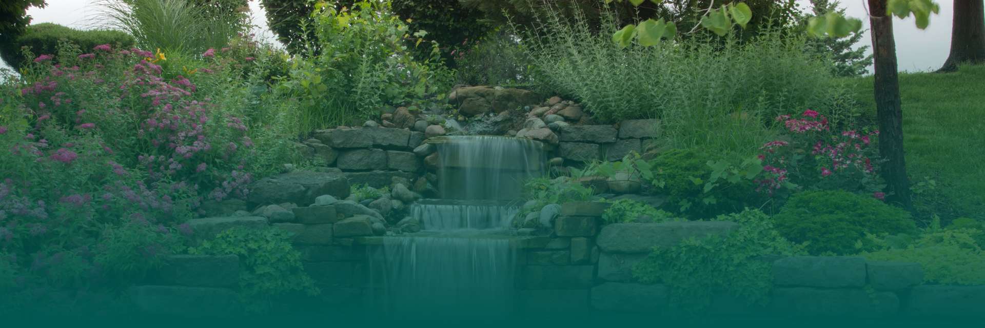 A serene garden with a waterfall surrounded by colorful flowers