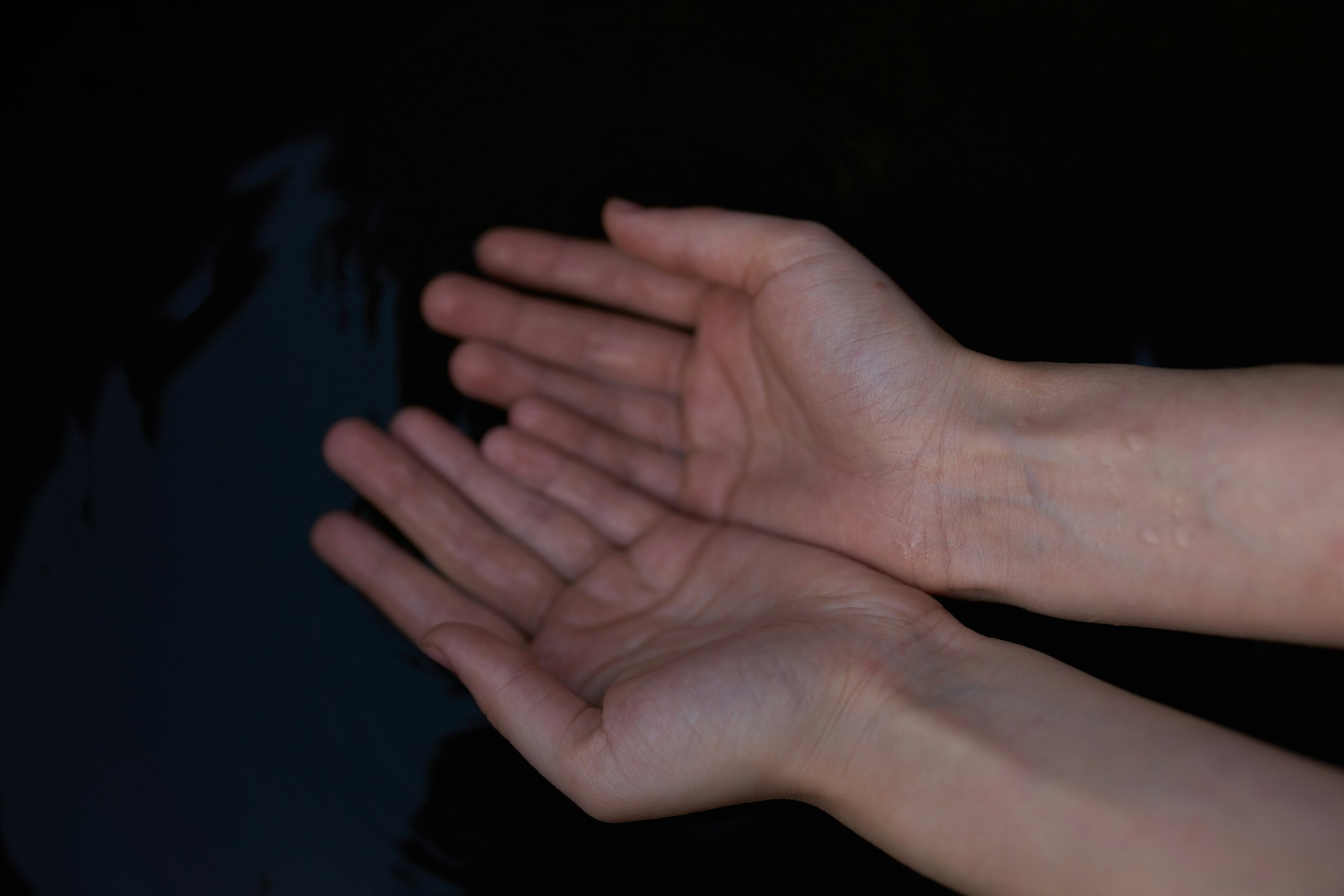 Two open hands against a dark background