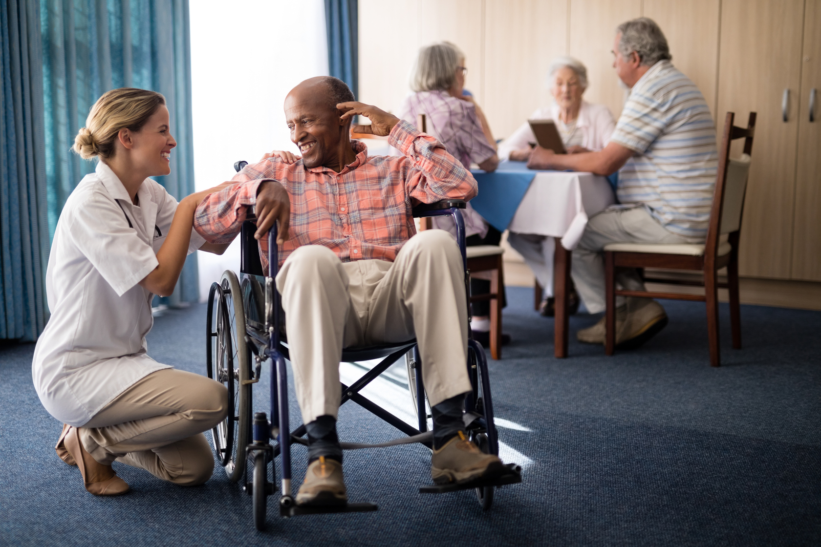 Care staff assisting a resident in a common area