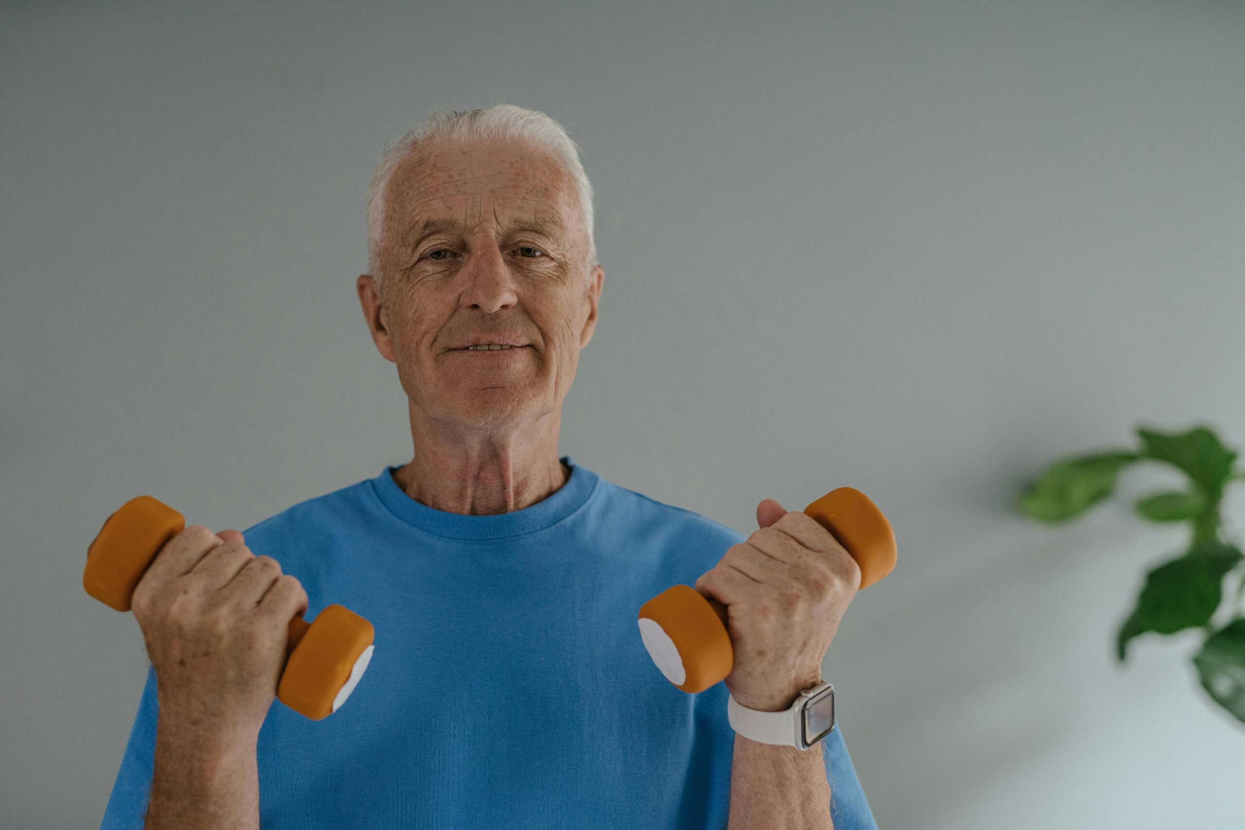 Senior resident exercising with weights indoors