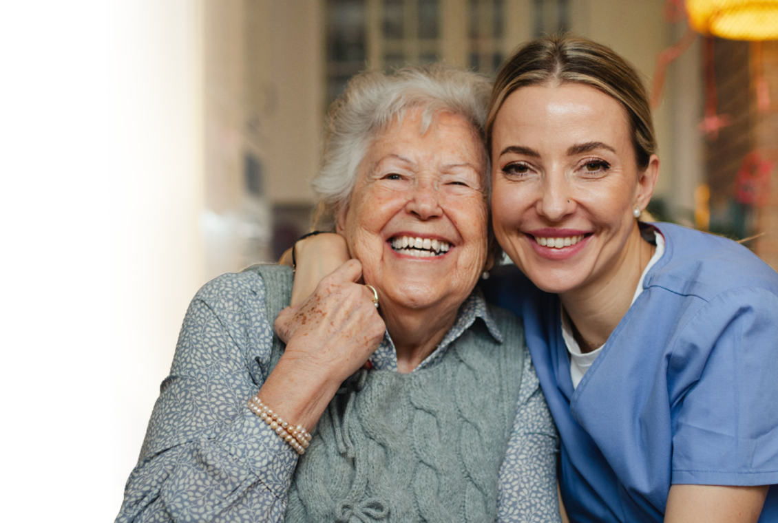 Caregiver and resident smiling together.