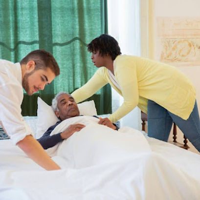 Care staff assisting a resident in bed