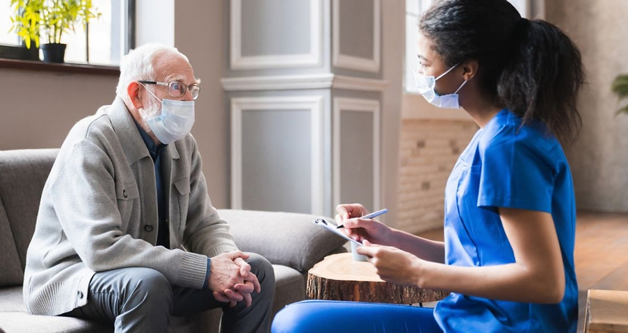 A caregiver discussing with an elderly resident indoors.