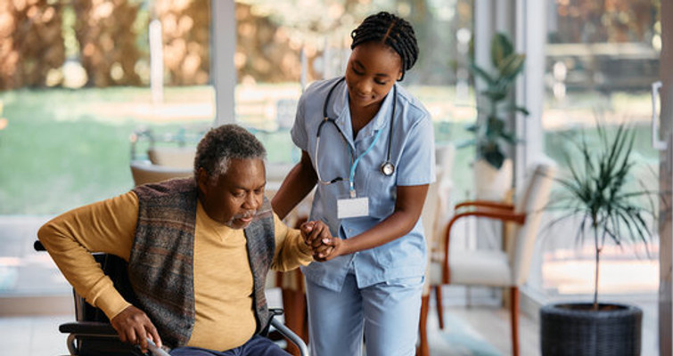 Caregiver assisting an elderly man in a comfortable setting