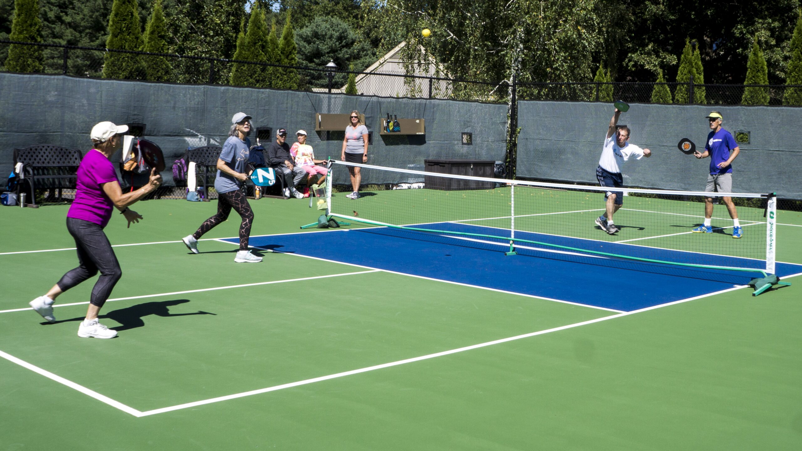 Residents enjoying a game of tennis outdoors.