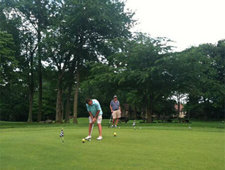 Two men playing golf on a green