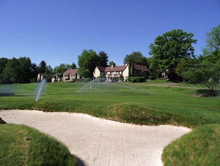 Golf course with residential buildings in the background.