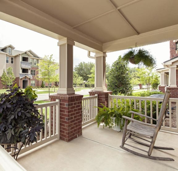 Porch with rocking chair and view of greenery