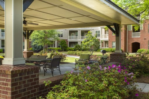 Outdoor seating area with flowers and buildings in background.
