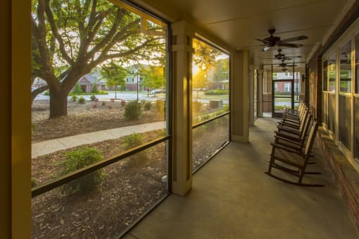 Sunlight filtering through a porch with rocking chairs.
