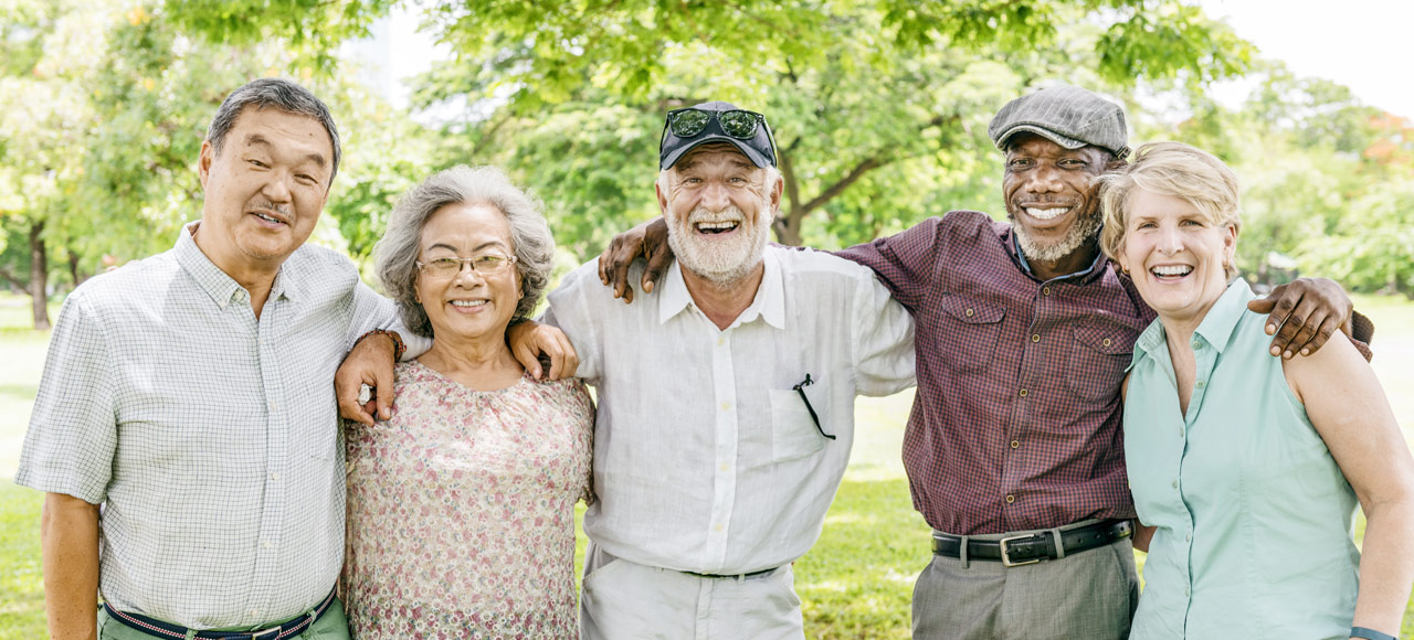 Group of seniors smiling together outdoors.