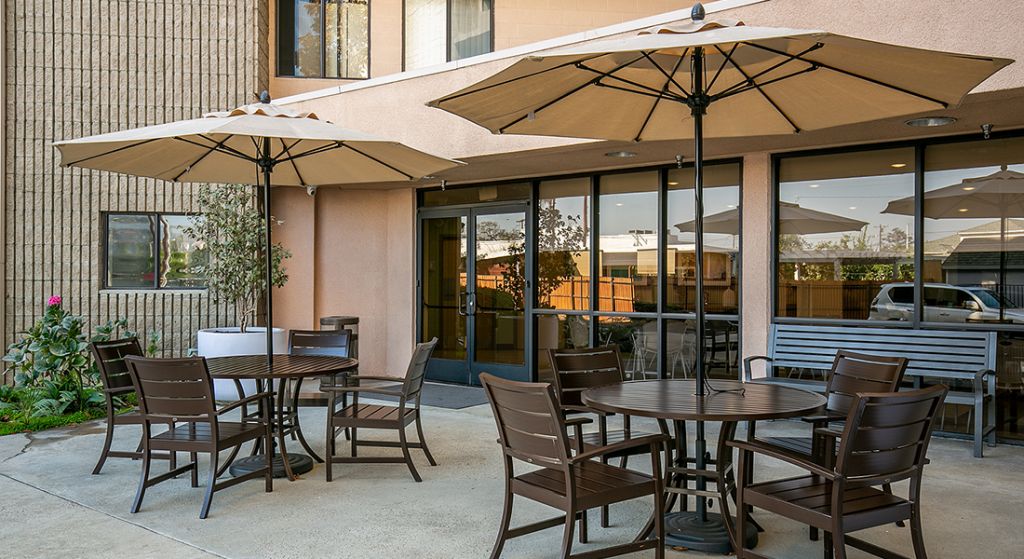 Outdoor seating area with tables and umbrellas.