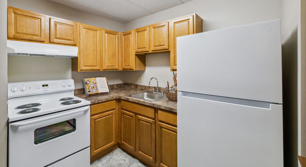A kitchen area with wooden cabinets.