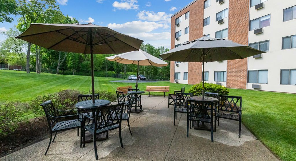 Outdoor seating area with umbrellas and greenery.
