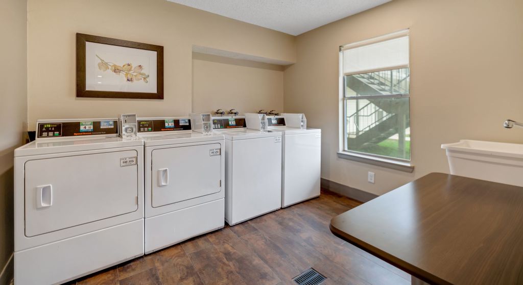 Laundry room with washing machines and a table.