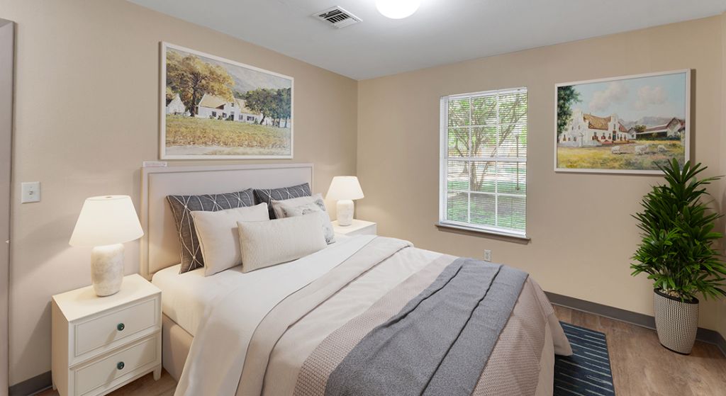 Brightly decorated bedroom with artwork and plants.