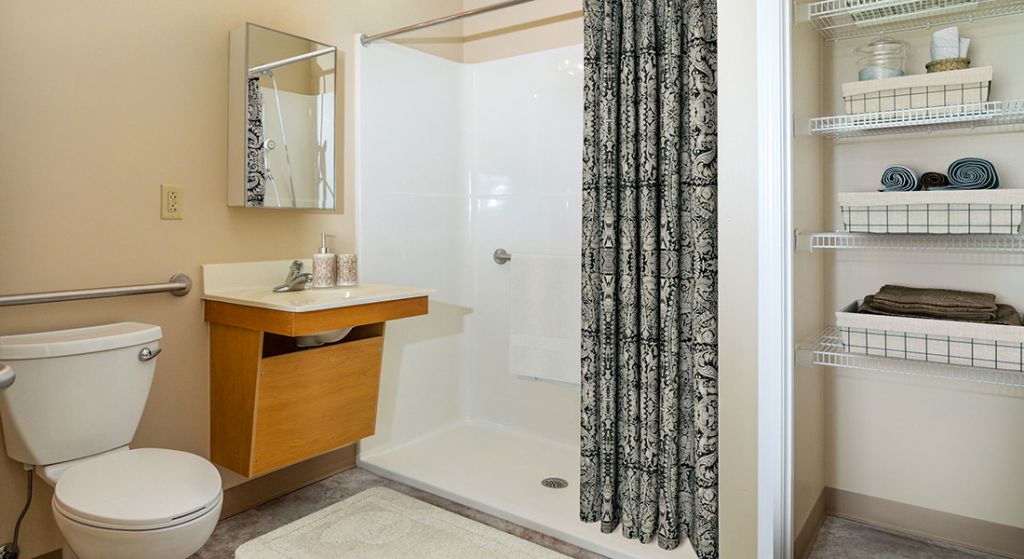 Well-lit bathroom with modern fixtures and storage.