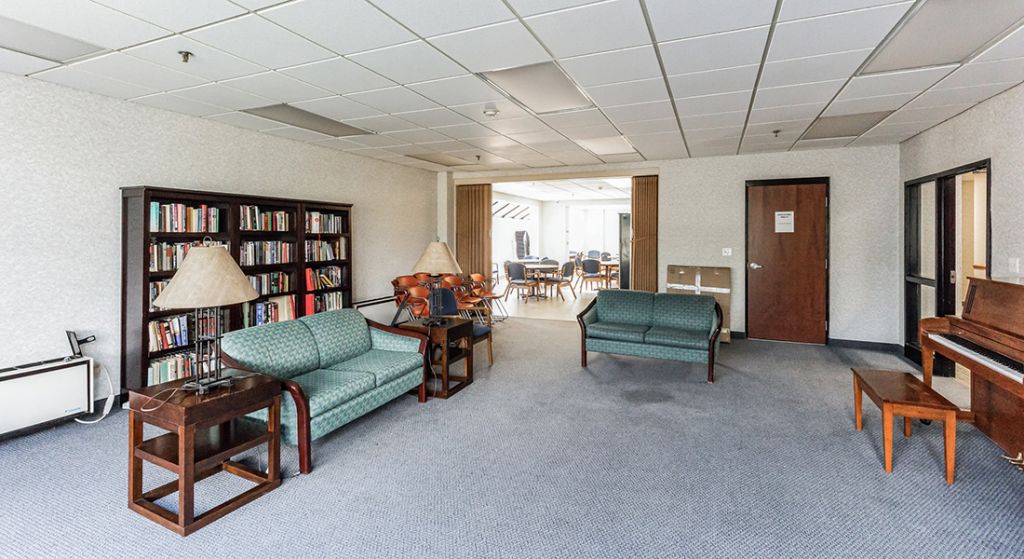 Cozy common area with seating and bookshelves.