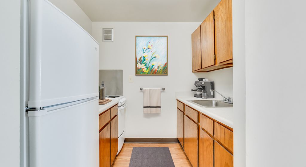 Clean kitchen space with white appliances and artwork