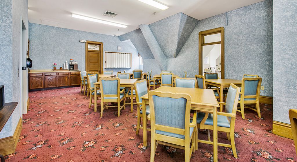 Dining area with tables and chairs in a common room.