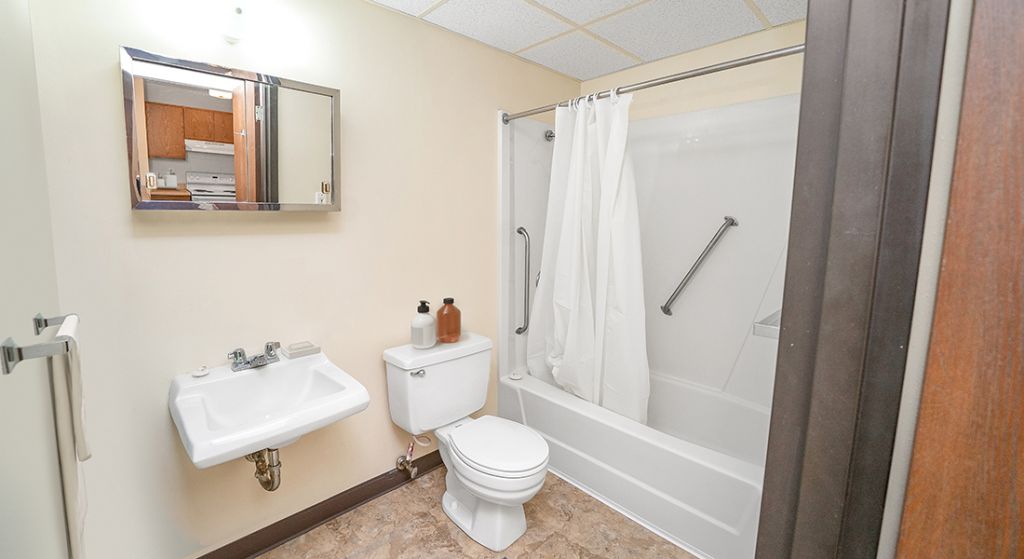 Clean bathroom with sink and shower area.