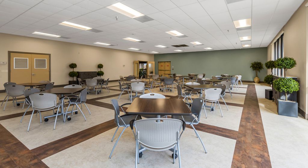 Spacious common area with tables and chairs arranged.