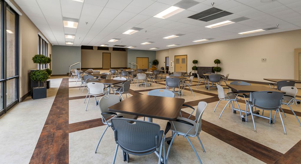 A spacious common area with tables and chairs.