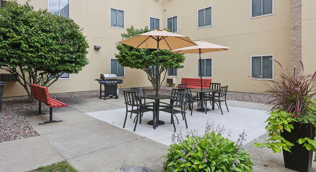 Outdoor seating area with umbrellas and grill
