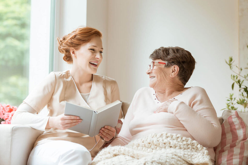 A caregiver and resident sharing a joyful moment indoors