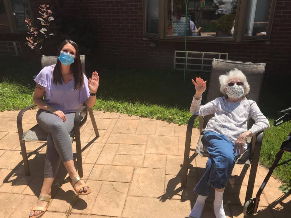 Residents and staff enjoying time outdoors, waving