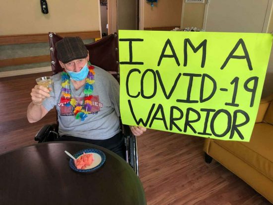 Resident holding a sign celebrating resilience during COVID-19