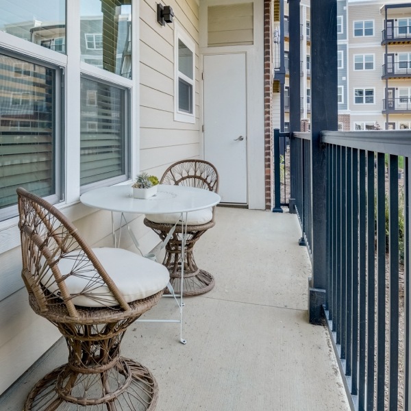 Balcony area with two chairs and a small table