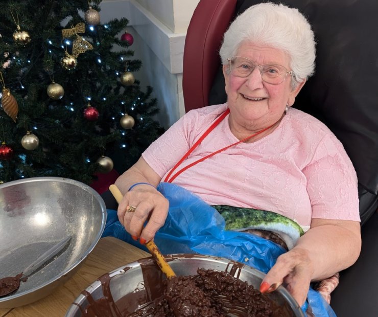 Resident baking with chocolate in a decorated space.