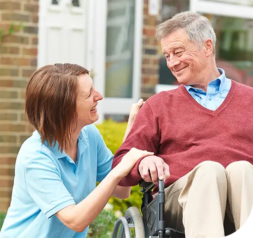 Staff assisting a resident outdoors in a wheelchair.