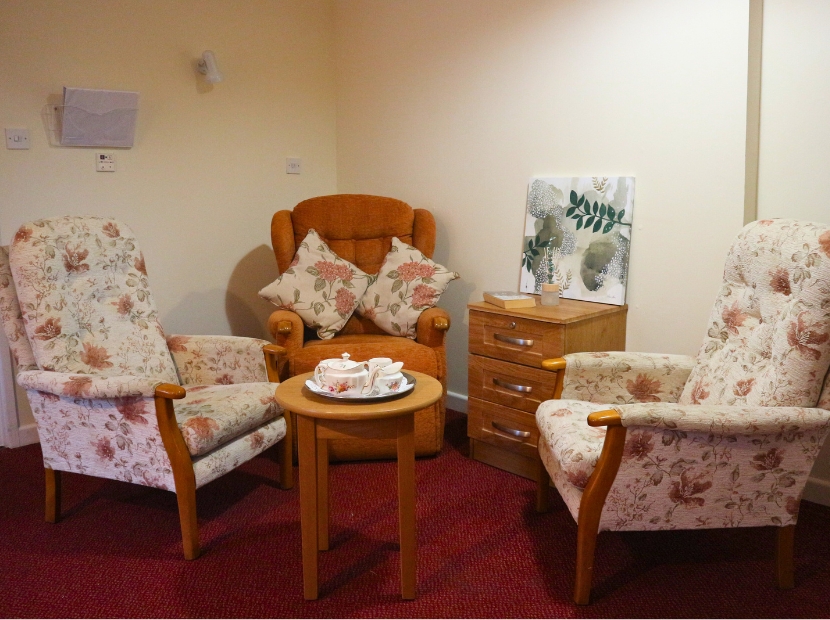 Cozy seating area with floral chairs and small table.