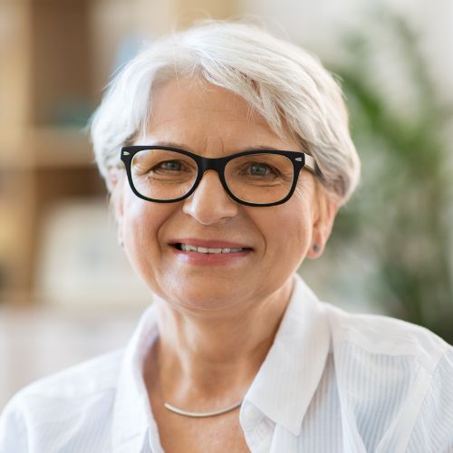 Smiling elderly woman with glasses indoors