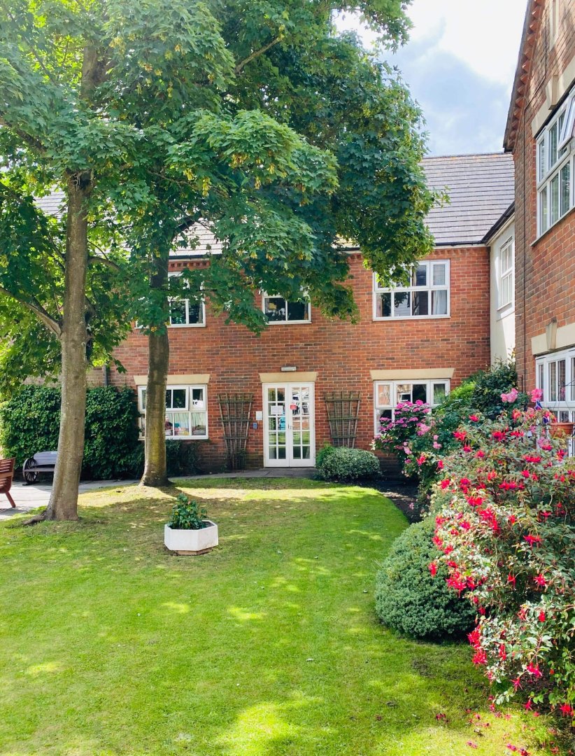 Exterior view of Cedar Court Care Home with garden