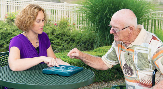 Staff member engaging with senior resident outdoors