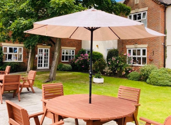 Outdoor seating area with umbrellas and greenery.